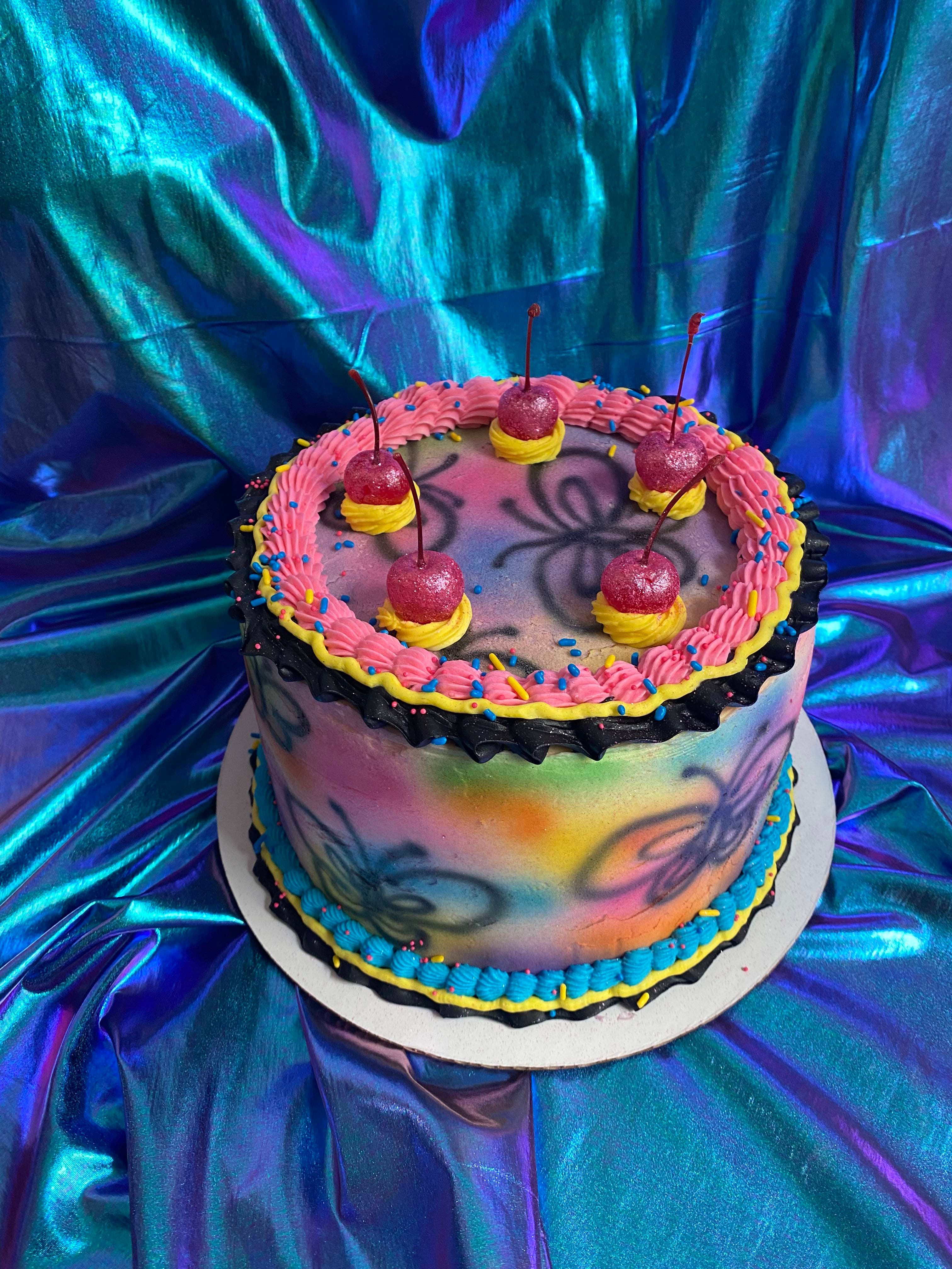 photo of a round cake with airbrushed butterflies