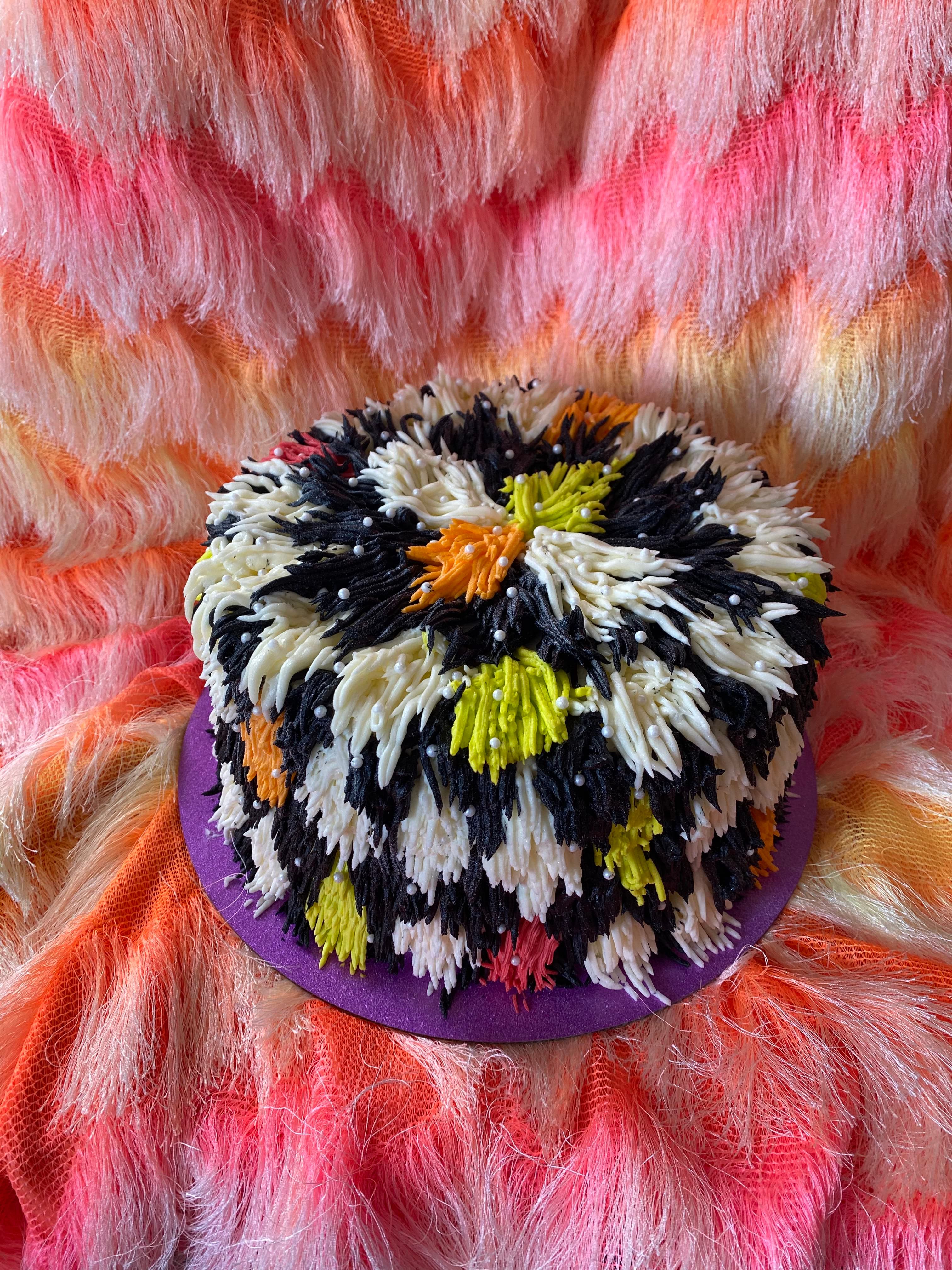 photo of a round shag carpet textured cake with a black and white checkerboard print