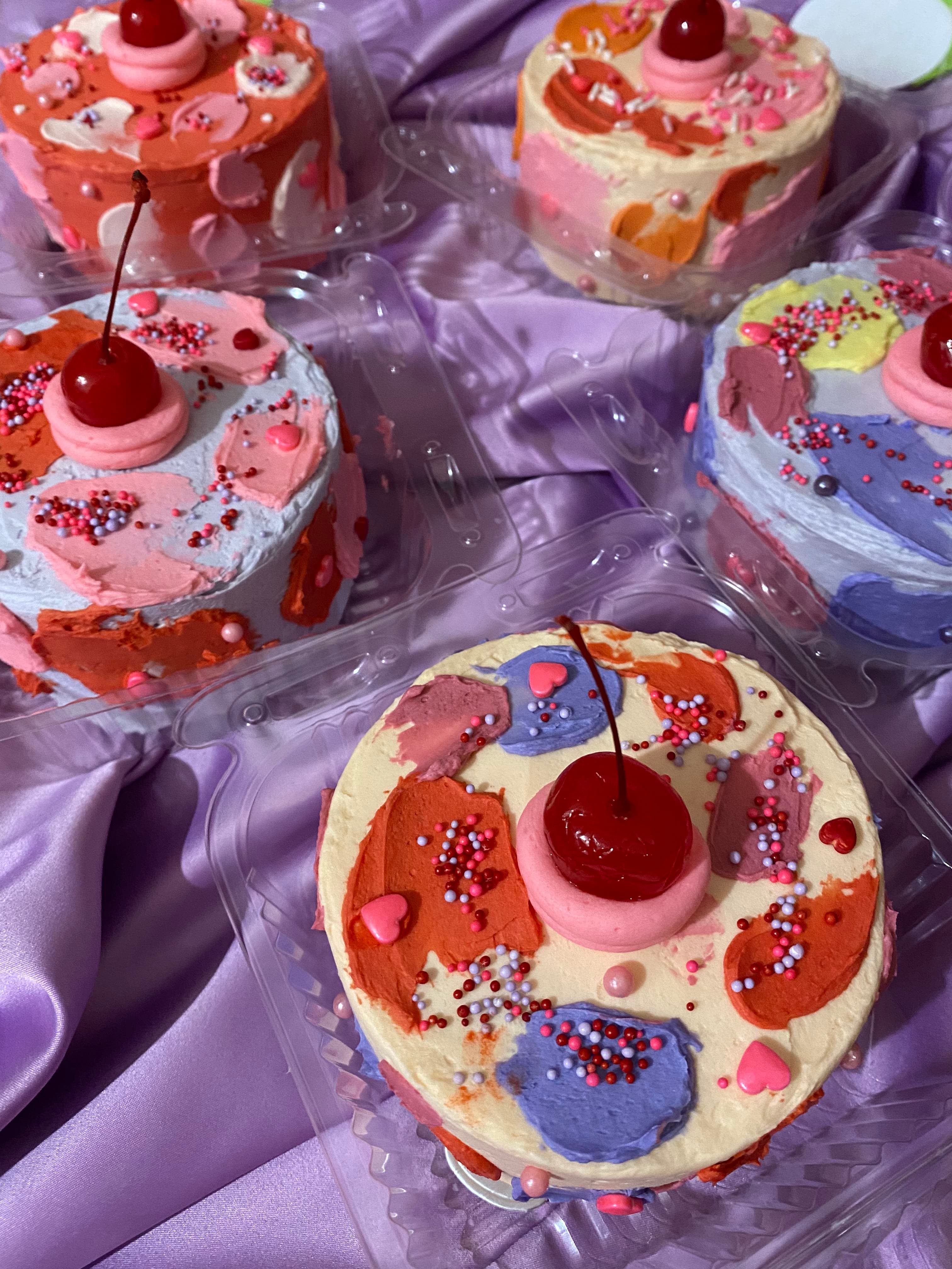 photo of a round mini cakes with abstract pallet brush marks like that of a painting